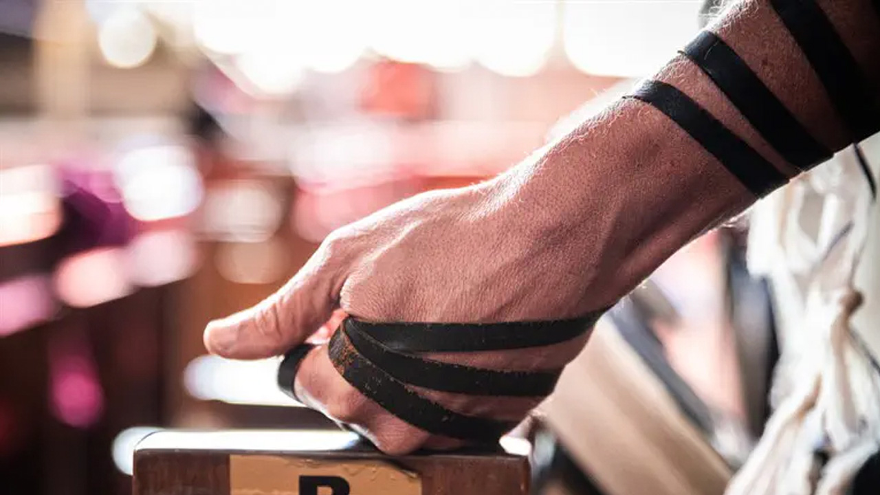 Close up image of a man's arm wrapped in tefillin.